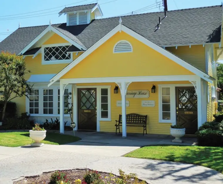 Front exterior of the Law Office of Sheny Gutierrez in Santa Ana. A yellow, two-story building with white trim.