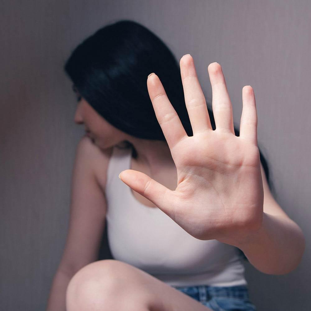 Assault - Woman holding out hand to block attacker.